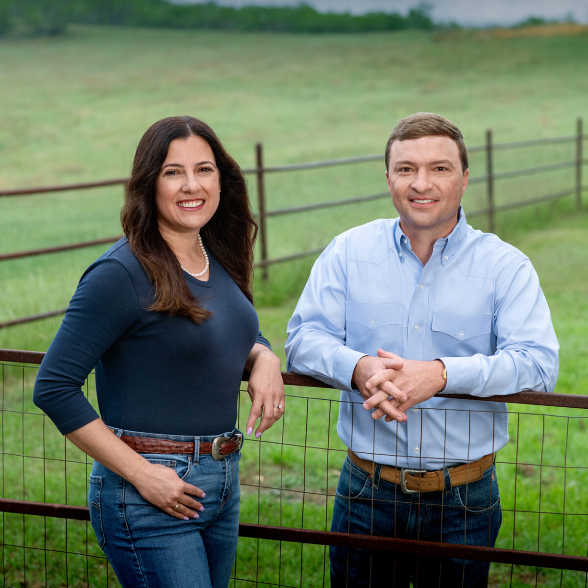 Emerging Leaders Institute hosts, Ben and Laura, standing in front of a farm field