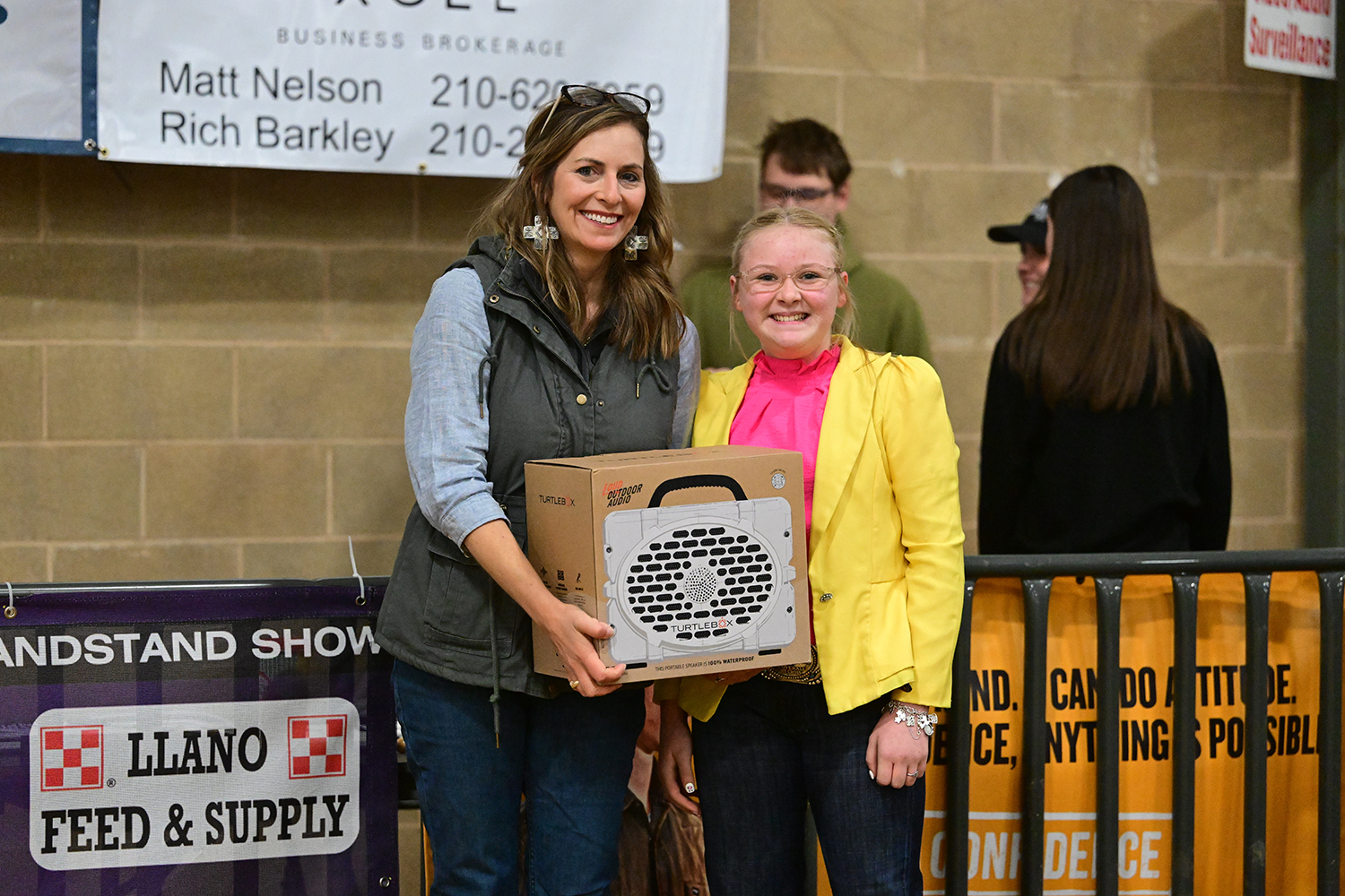 A CFC employee presents a young girl with a portable speaker prize