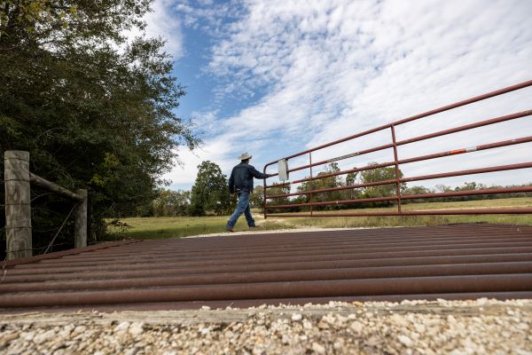 Man opening a farm gate.
